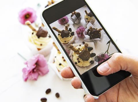 A photo being taken of pretty cupcakes on a phone