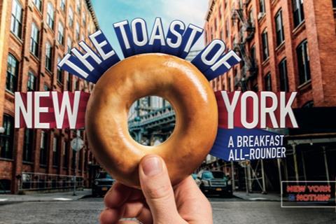 A bagel with the words 'The Toast of New York' and a New York street in the background