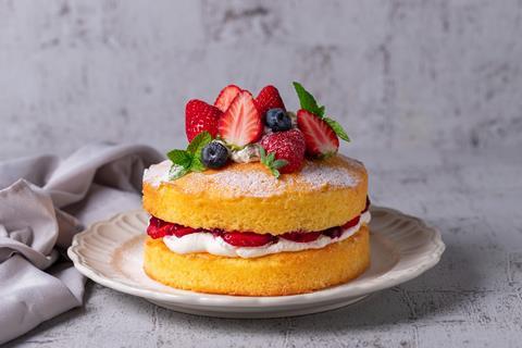 A victoria sponge cake with strawberries and blueberries on top