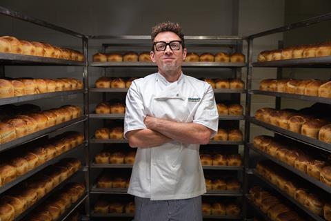 A room full of sourdough loaves with Jason Geary in baker's whites in the middle