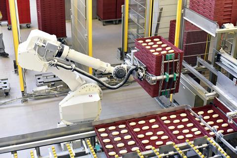 Robot arm lifting pallets of bread rolls
