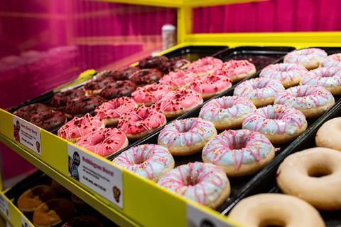 Bright coloured ring doughnuts in a pink cabinet