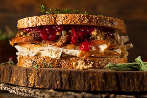 Thanksgiving leftovers sandwich with turkey and stuffing on seeded bread