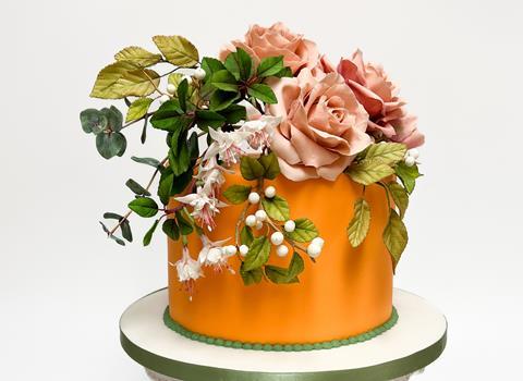 A beautiful orange cake with sugar paste flowers on top