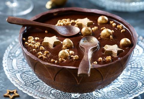 A chocolate bowl with chocolate filling and gold edible stars on top