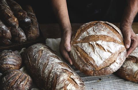 A round sourdough loaf being presented to the camera