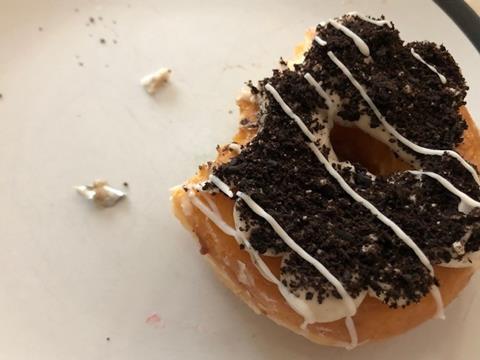 A doughnut with a piece of metal next to it