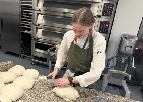 Ella Muddiman in a green apron baking