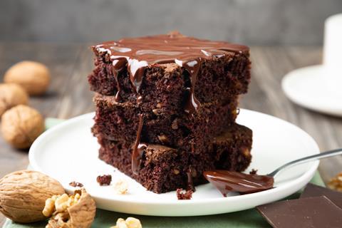 A stack of chocolate brownies with chocolate sauce on top