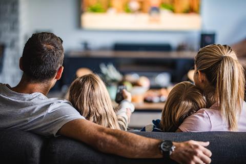A family with two children watching TV