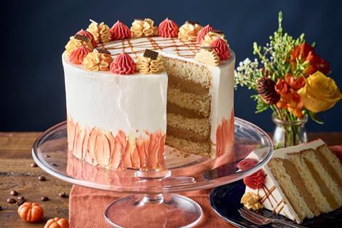 A layer cake with cream frosting and red and orange decorations