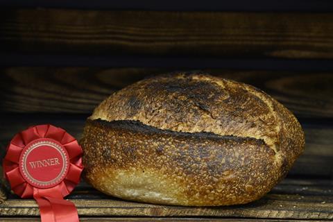 A crusty sourdough loaf next to a winner's rosette