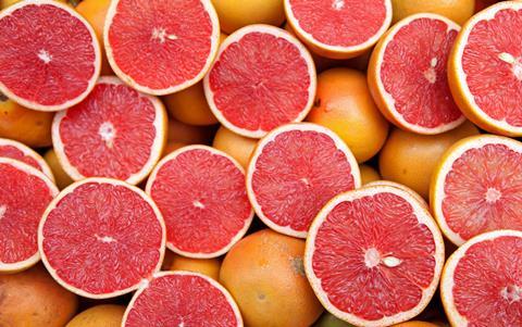 A close up shot of lots of sliced pink grapefruits