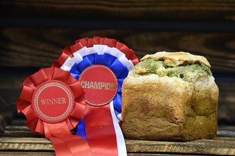 A green brioche loaf next to two winner's rosettes