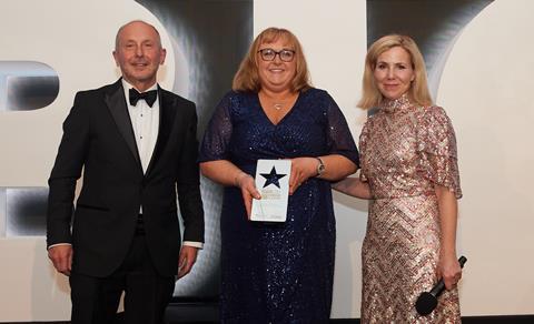 Caketastic Creation's Johanna Moloney (centre) receives the award from Finsbury Food Group non-executive chairman Peter Baker and Baking Industry Awards celebrity host Sally Phillips