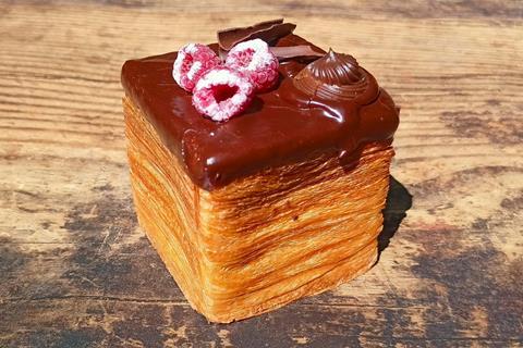 A cube croissant with chocolate ganache and raspberries on top