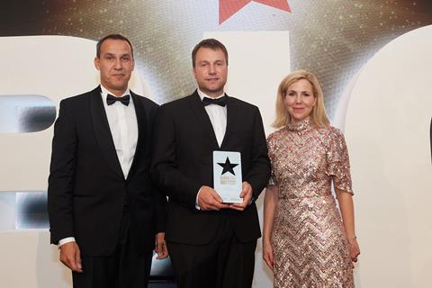 Mark Johnstone (centre) receives the Customer Focus Award 2022 for the team at Roses the Bakers from Frederic Trombert of CSM Ingredients and celebrity host Sally Phillips