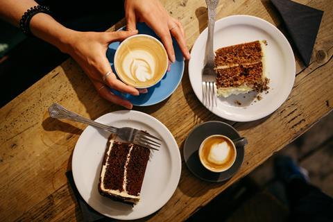 A bird's eye view of a latte and two slices of cake