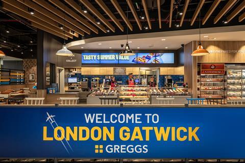 Inside a Greggs in Gatwick airport - with a large blue sign saying 'Welcome to London Gatwick Greggs'