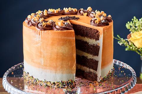 Four layer chocolate cake with orange frosting and dark chocolate swirls