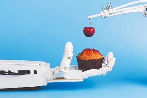 Robot hand holding cupcake with cherry