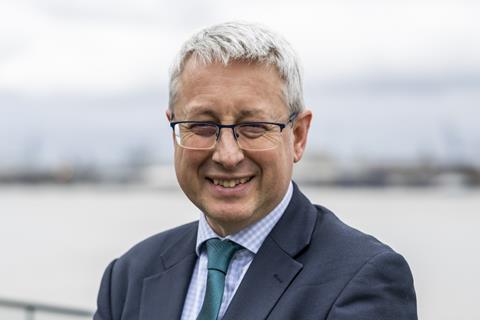 Alistair Gale in a suit and tie by a river