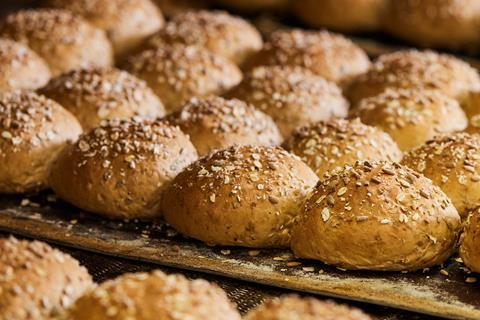 Fresh bread rolls with oats on top coming out of the oven
