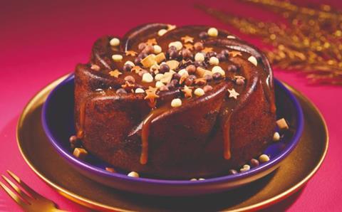 A star shaped pudding with fudge pieces and chocolate chunks on top, with a salted caramel sauce