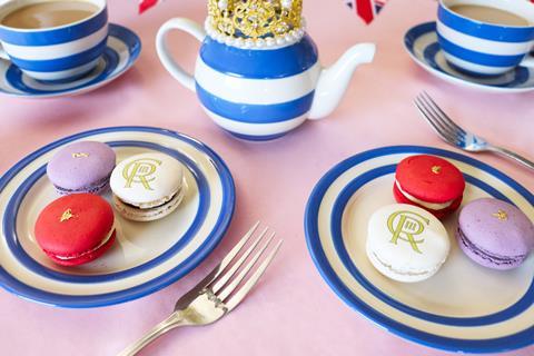 Two plates of Coronation Macarons on a table with cups of tea and a teapot.
