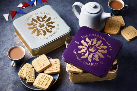 A commemorative biscuit tin accompanied by biscuits and bunting