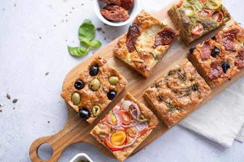 Slices of Multiseed Foccacia with different toppings on a wooden board