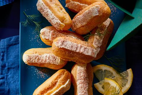 A stack of Smoked Salmon Eclairs with fresh dill on a blue plate