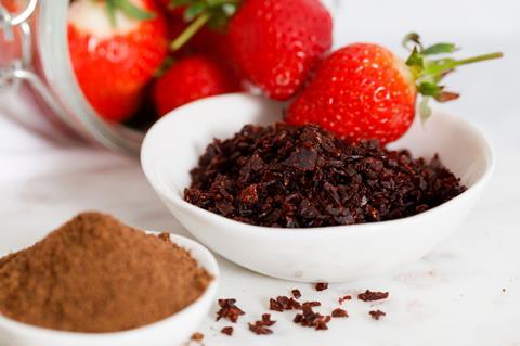 Air dried strawberries in a bowl next to fresh strawberries