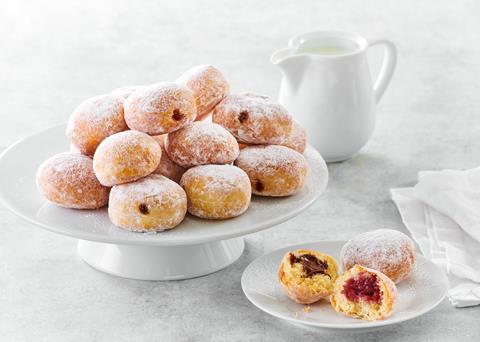 Mini icing sugar dusted doughnuts on a white plate