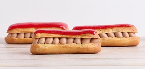A side on view of three vegan eclairs with red icing