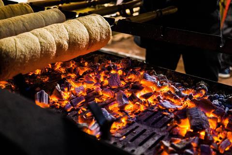 Chimney cake being baked over hot coals