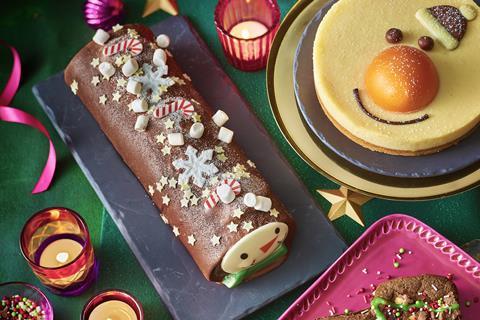 A Swiss roll with a snowman face and mini marshmallows on top