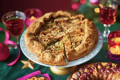 A butternut squash galette on a festive looking table with glasses of wine around it