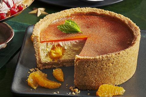 A spiced orange cheesecake with a slice taken out of it, and orange topping