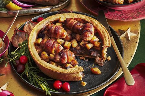 A Pigs in Blankets Topped Pie on a festive table