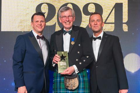 A shocked but happy George Stevenson receives the Outstanding Contribution to the Baking Industry award from Richard Freeman, UK & Ireland commercial director at Délifrance, and celebrity host Scott Mills