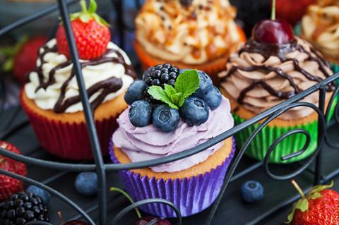 A selection of luxurious cupcakes with fruit and drizzles on top