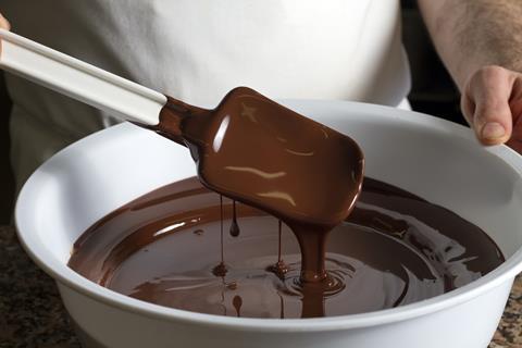 A bowl of chocolate with a spatula in it