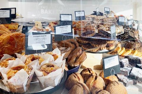 Cakes, muffins, cookies and tarts in the window of Two Magpies Bakery