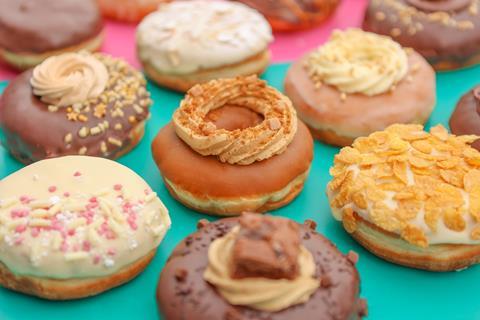 Chocolate and caramel doughnuts on a pink and turquoise background