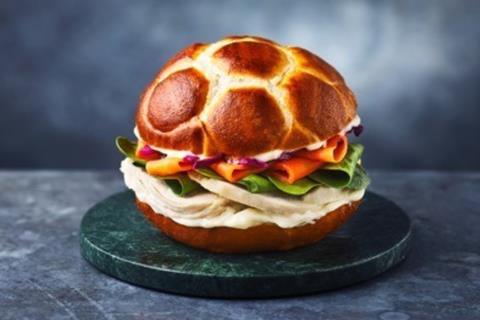 A chicken and slaw sandwich in a soft bun with football markings on top