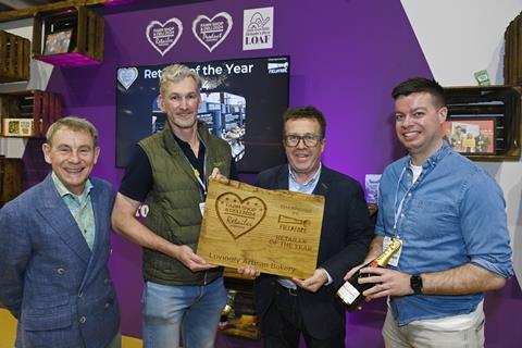 Four mean holding a wooden trophy and smiling at the camera