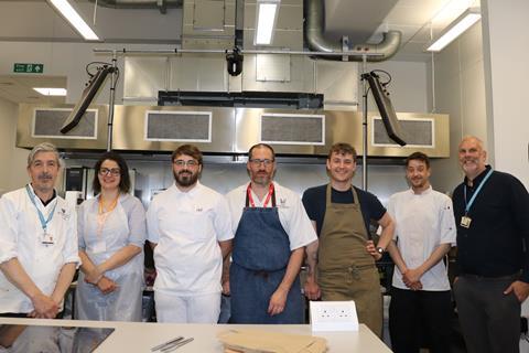Plumpton College - Food Industry Skills programme manager Anthony Gaston (right) and bakery lecture Aidan Chapman (left) stand with the Level 3 Lead Baker apprentices in the training kitchen - 2100x1400