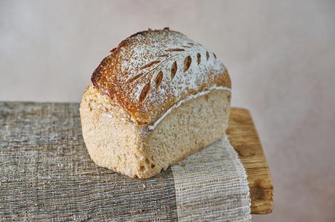 A sourdough tin loaf on a cream and grey background