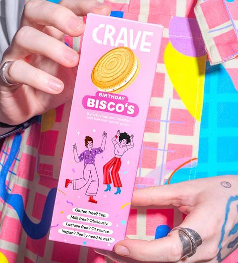 A box of Birthday Bisco's biscuits being held by someone in colourful pink dungarees
